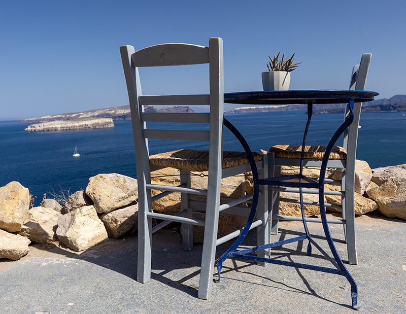 Tisch und Stühle vor der Caldera von Santorin