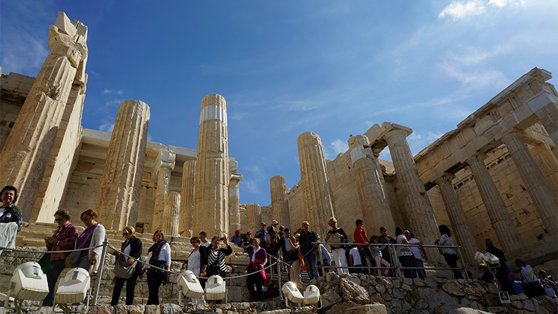 Touristen strömen über die Propyläen in die Akropolis